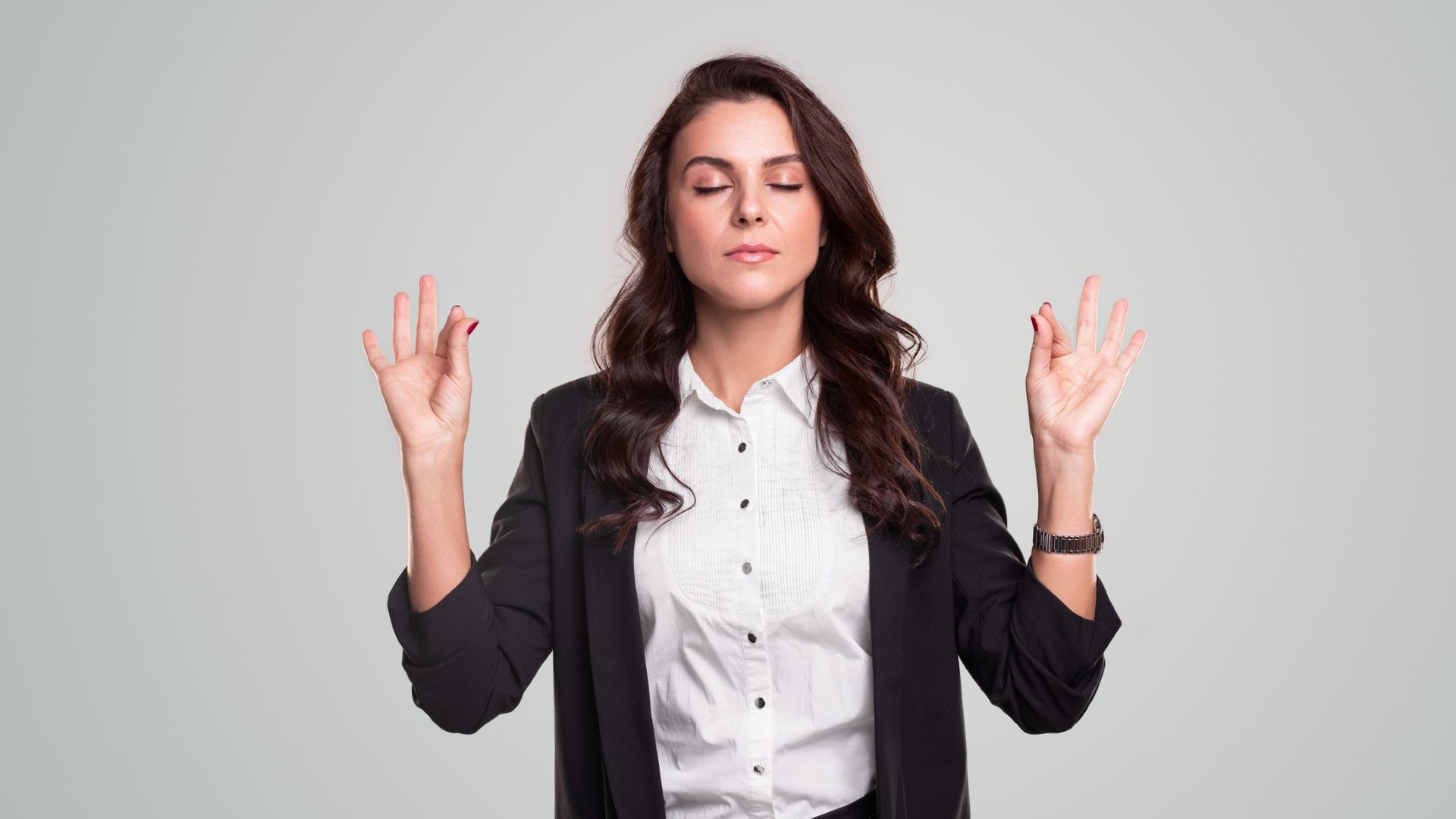 woman doing meditation mudra in business clothes